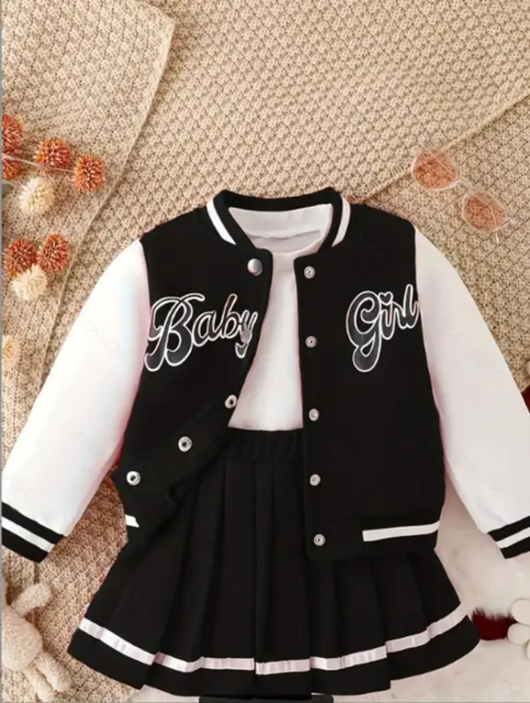 Offrez à votre petite princesse un look tendance et adorable avec cet ensemble composé d’une veste style universitaire et d’une jupe plissée assortie. Confortable et élégant, il est parfait pour toute